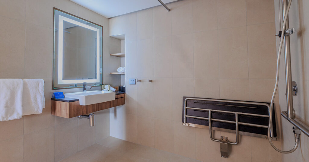 Accessible bathroom in Deluxe Accessible King at Wrest Point with fold-down seat and roll-in shower