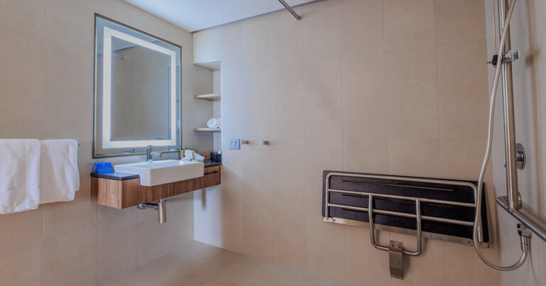 Accessible bathroom in Deluxe Accessible King at Wrest Point with fold-down seat and roll-in shower