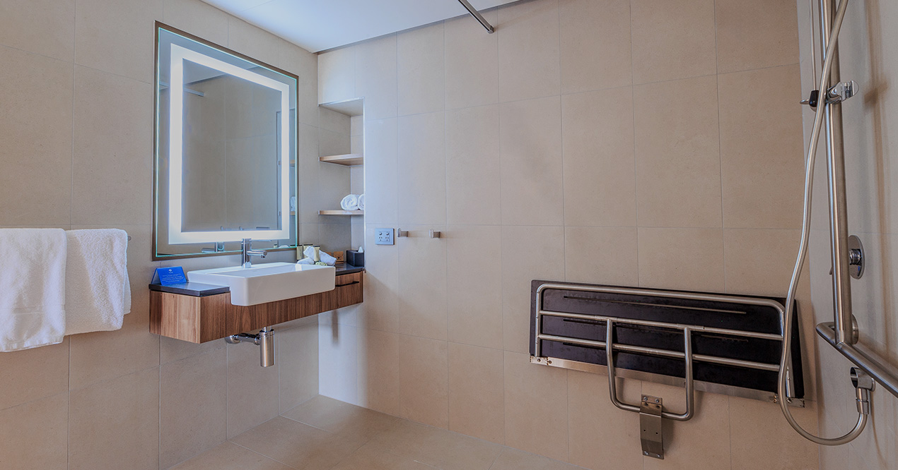 Accessible bathroom in Deluxe Accessible King at Wrest Point with fold-down seat and roll-in shower