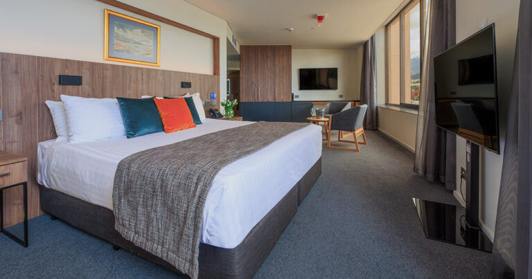 Deluxe Accessible King room at Wrest Point featuring king bed, timber finishes and lounge chairs