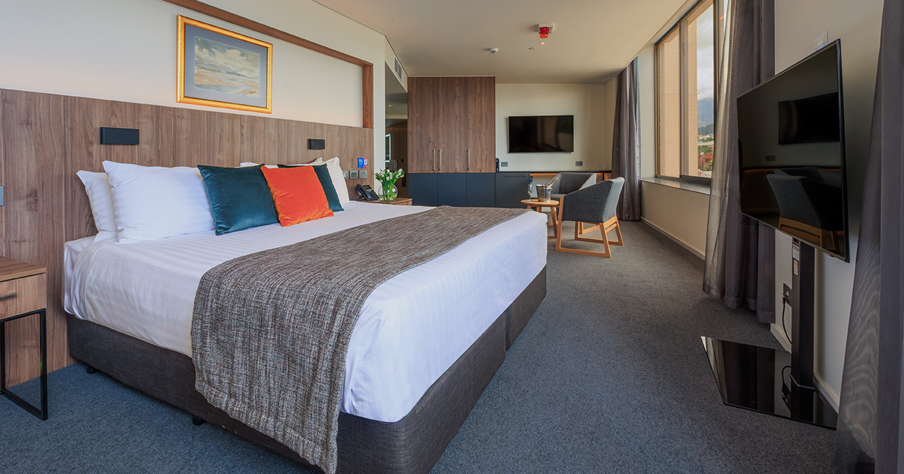 Deluxe Accessible King room at Wrest Point featuring king bed, timber finishes and lounge chairs