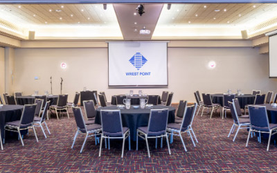 Interior of the Wellington Room at Wrest Point Hotel, set up with round tables and audiovisual projectors.