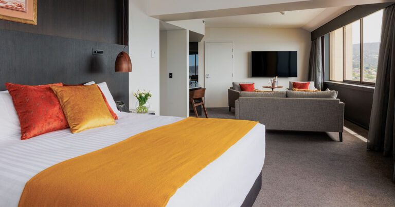 Open-plan Harbour Suite at Wrest Point with king bed and separate lounge area