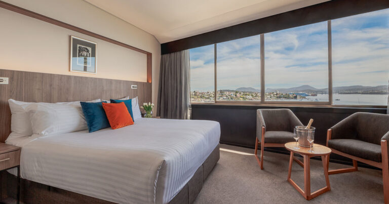 Harbour View Deluxe King room at Wrest Point with king bed, armchairs and sweeping harbour views