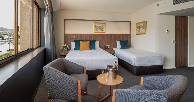 Interior of Mountain View Deluxe Twin at Wrest Point with two beds and lounge chairs